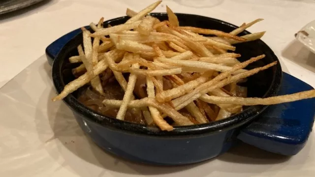 Calamaretes encebollados con lluvia de papas crujientes.