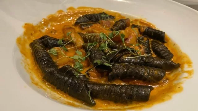 Cavatelli negros con tinta de calamar (pasta fresca casera en forma de penne rigati hecho a mano) y rulos de calamar con salsa de mejillones al vermouth.
