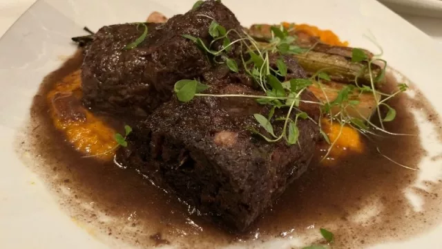 Cachete de ternera (quijada, carrillera o meloso, denominación según las distintas regiones) en larga cocción, acompañado con vegetales confitados, salteado con su propio jugo.