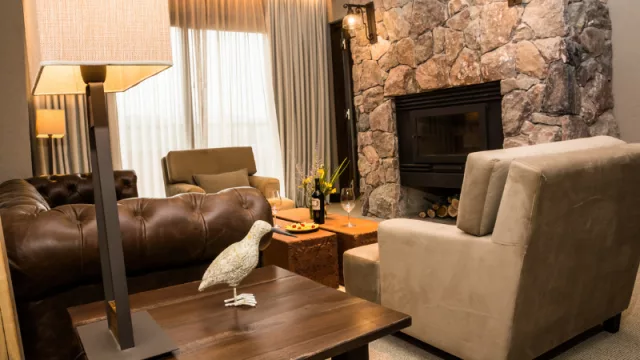 Hogar a leña y un cómodo living en la suite presidencial.