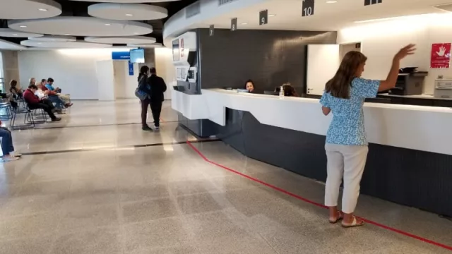 Escritorio de recepción, delimitado con una cinta roja (para indicar a pacientes donde deben pararse).
