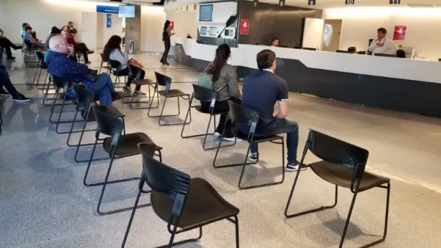 Sala de espera con número reducido de asientos, ubicados a mayor distancia entre ellos.