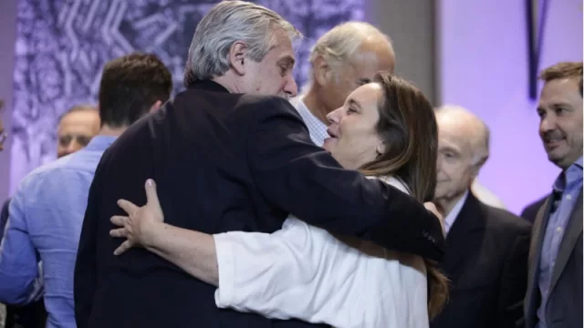 Alberto Fernández se saluda de manera efusiva con Pía Astori, presidente de la Fundación Mediterránea.