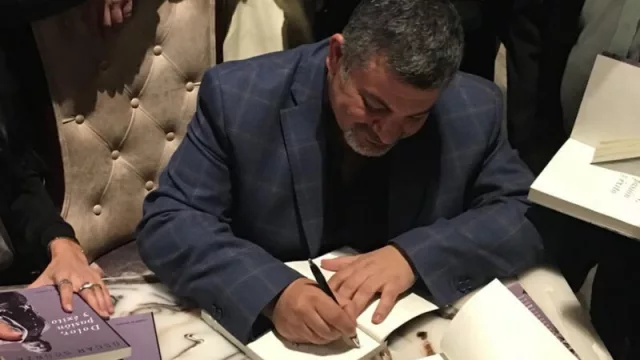 Oscar Scorza firmando los libros de fueron obsequiados a los asistentes. 
