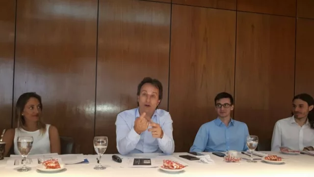 Dequino da su visión sobre la economía. Observan, a su derecha, Costantino y, a su izquierda, Cuesta y Veltre. 