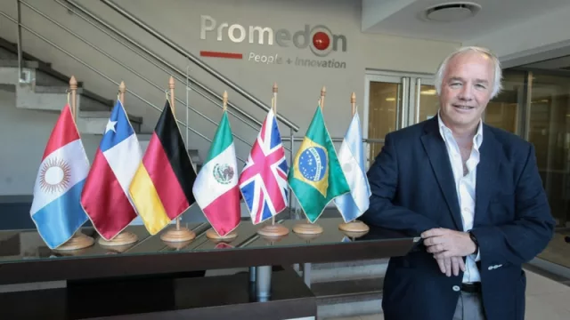 Sin Fronteras. Olmedo posa junto a las banderas de distintos países en el ingreso a su headquarter.