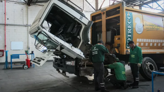 Un grupo de mecánicos de la empresa acondiciona uno de los 100 camiones que componen la flota de la compañía.