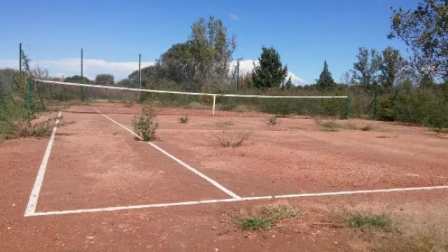 ¿Césped o polvo de ladrillo? La cancha de tenis de la urbanización de excelencia está inutilizable.