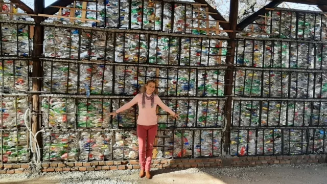 Verónica Diedrich, Jefa Comunal Villa La Bolsa, junto a una pared con 300 bloques PET que tienen un tamaño aproximado de 28 x 59 x 55. 

Una localidad que apuesta a la economía circular.