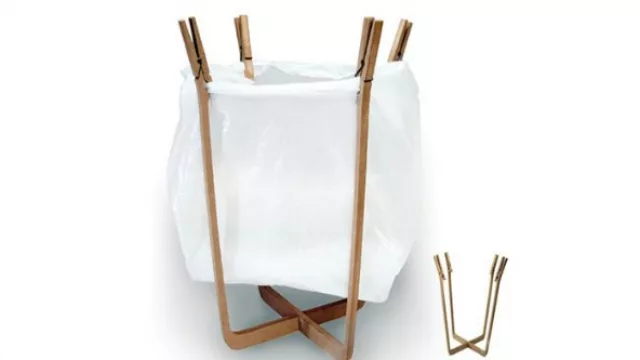 No es práctico pero sí original: un basurero con gancho para la ropa que sostienen la bolsa.