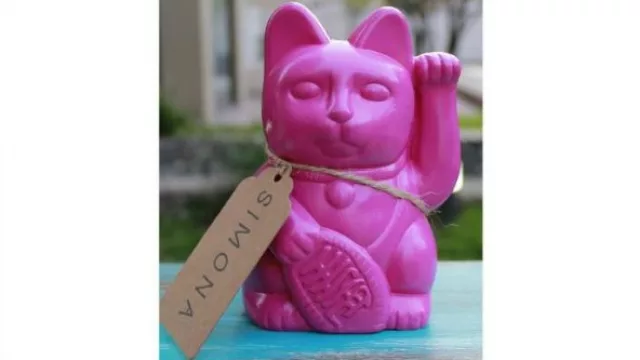 Gato de la fortuna de plástico fucsia disponible en MercadoLibre.
