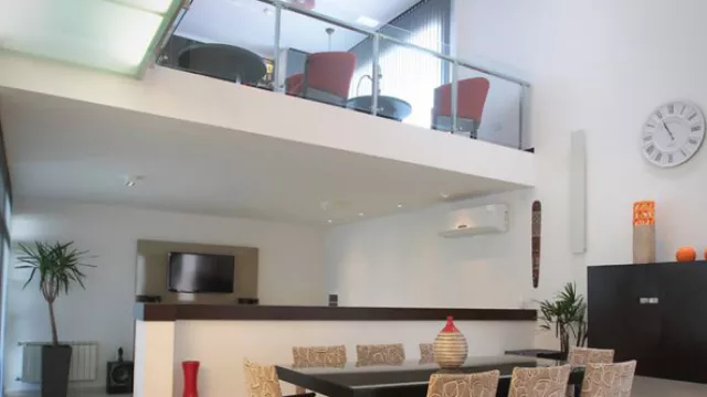 Los dos niveles de la casa se unifican en el comedor con paredes grandes logrando visuales amplias.  (Fotografía by Álvaro Corral)