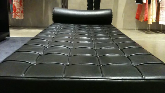 El sillón/diván estilo capitoné es -junto al espejo- una de las piezas centrales del espacio.