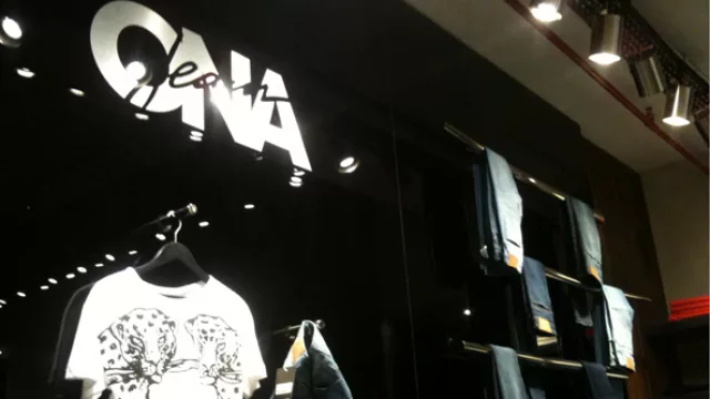 Las paredes de acrílico negro contrastan con las ramas/percheros de metal.