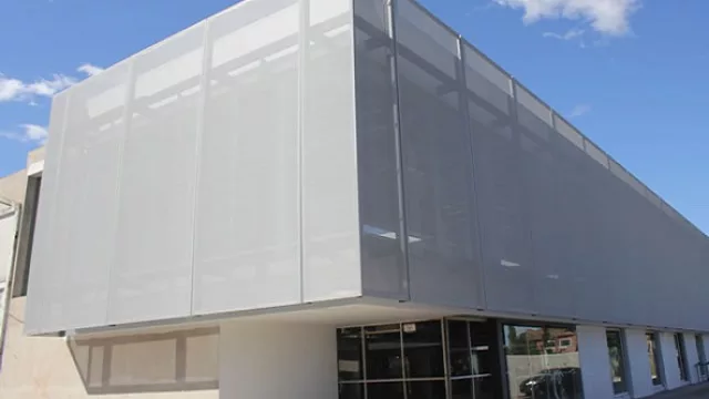 Membrana textil tensada vinculada a una estructura de anclaje en el edificio de Droguería Sumed.