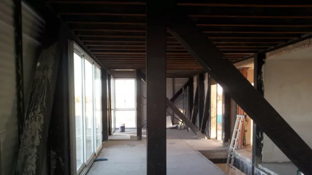 El interior de la planta alta deja entrever las chapas en las paredes y denota un estilo “industrial”, como el cliente lo pidió.