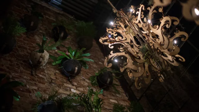 Las arañas son de madera y las macetas cubren por completo una pared que conecta la planta baja con el segundo piso.