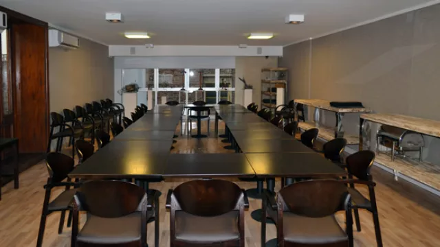 La mesa directorio de guatambú negro fabricada localmente. Los mesones laterales de madera reciclada (de la obra) con patas cromadas y pátina blanca.