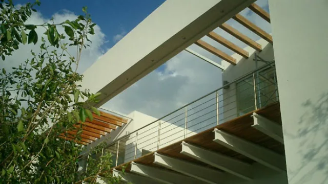 El deck del último nivel está protegido  por un pergolado interrumpido por tramos, materializado en madera.