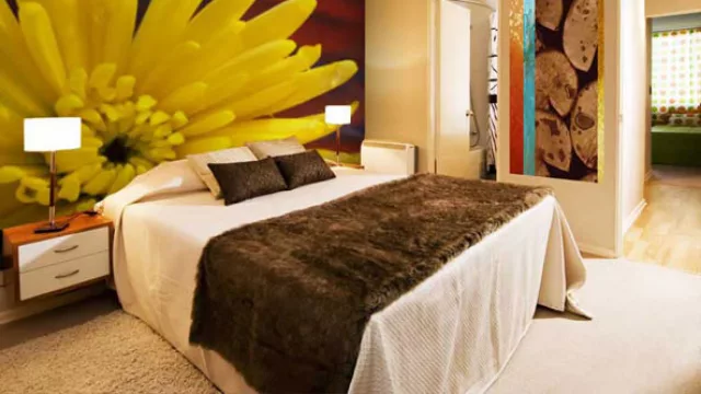 La habitación matrimonial dedicó el muro de cabecera de la cama con un motivo de la naturaleza para acompañar la paleta de colores.