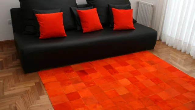 Este damero de cuadrados de 15x15, en color rojo estridente acapara el punto focal del estar rimando hábilmente con el mobiliario oscuro.