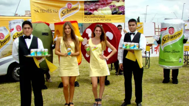 Las promotoras y los mozos invitando a automovilistas y peatones a degustar una Schweppes