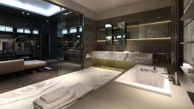 Paneles divisores de blindex  aíslan el sector húmedo del baño y a la vez lo integran  visualmente al vestidor.