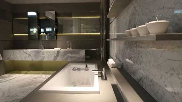 El baño está íntegramente revestido de mármol “Bianco  Estatuarietto” y mármol “Pietra Serena”  gris.