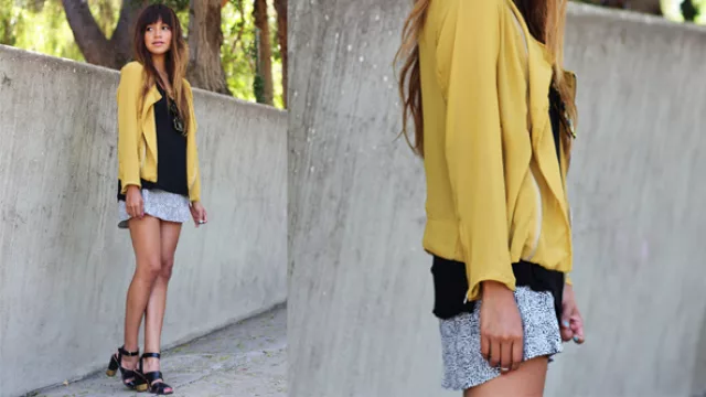 Arriba del vestido animal print gris y negro, musculosa negra y encima cazadora de seda en amarillo mostaza.