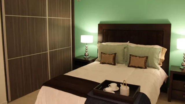 Cardinales Río IV. En la habitación principal se optó por colores frescos  lo cual propicia el rélax, y contrastan con las maderas lustradas de caoba.