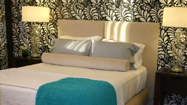 Alto Panorama en Córdoba. Las envolventes de la suite se revisten con papel vinílico diseñado para combinar con el respaldo, somier y banqueta cilindro.