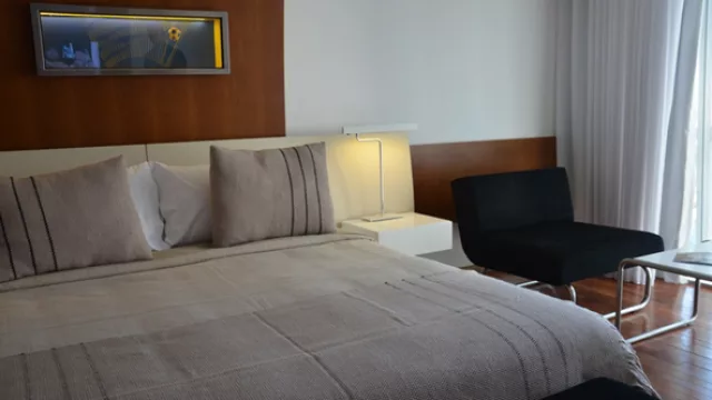 Así es una habitación: muy sobria en decoración, con toques azul y amarillo y amenities de un cinco estrellas