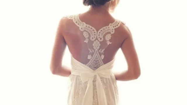 Vestido de casamiento, con impecable escote de guipiure que termina en lazo y moño en la cintura.