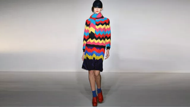 Sweater tejido a rayas, con movimientos en ángulos, marcando las pinzas y el evasse en falda. Falda de antè. 