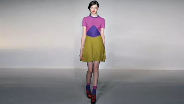 Vestido con molderías geométricas  haciendo jugar las rayas desencontradas, marcando cintura, sin ser ceñido al cuerpo. Atención en los zoquetes. 